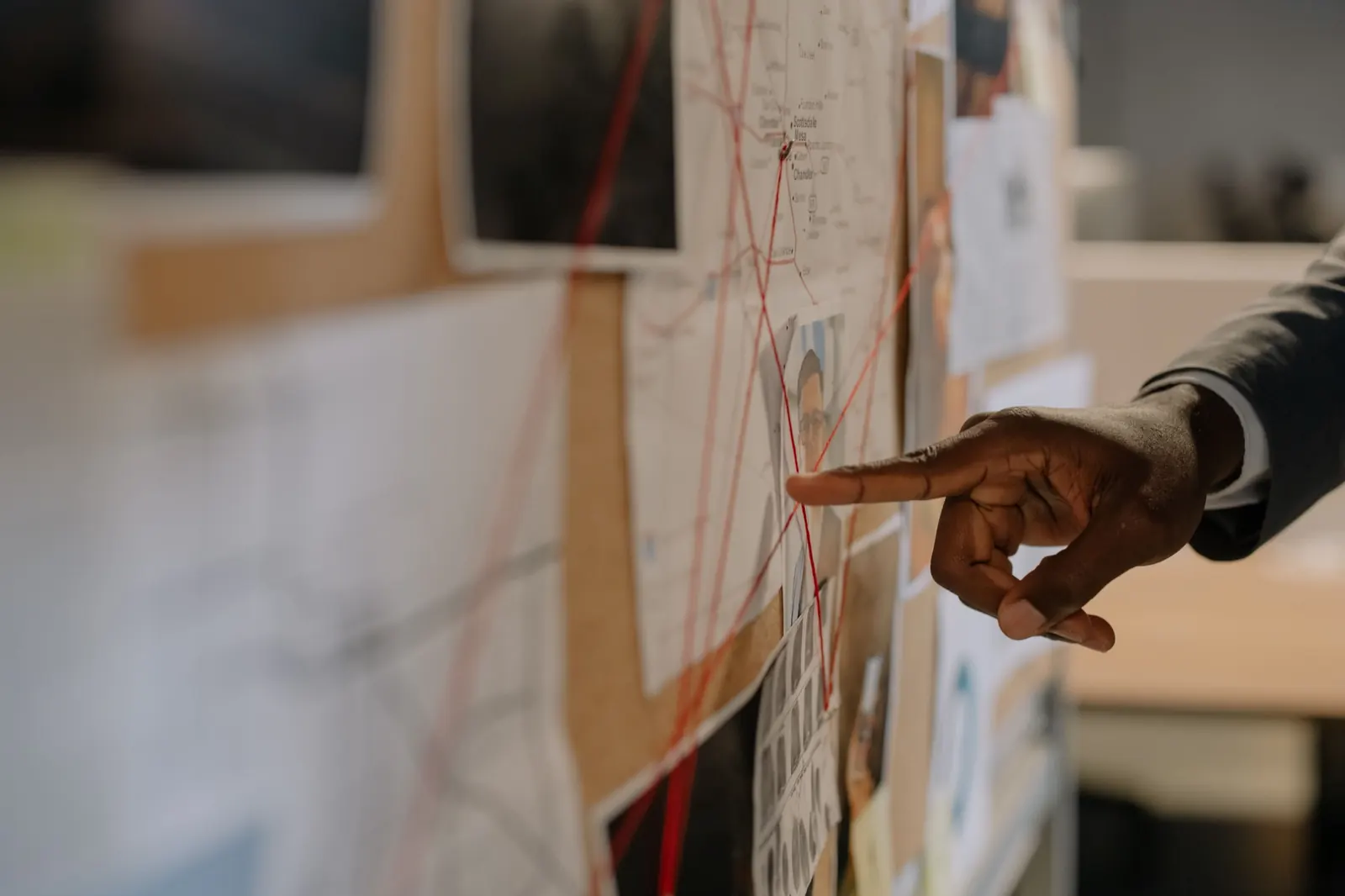 Investigation board with photos connected by red string